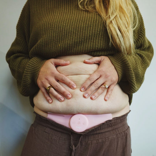 A natural soft tummy with a Tap 2.0 TENS attached to the curvy tummy pad. 